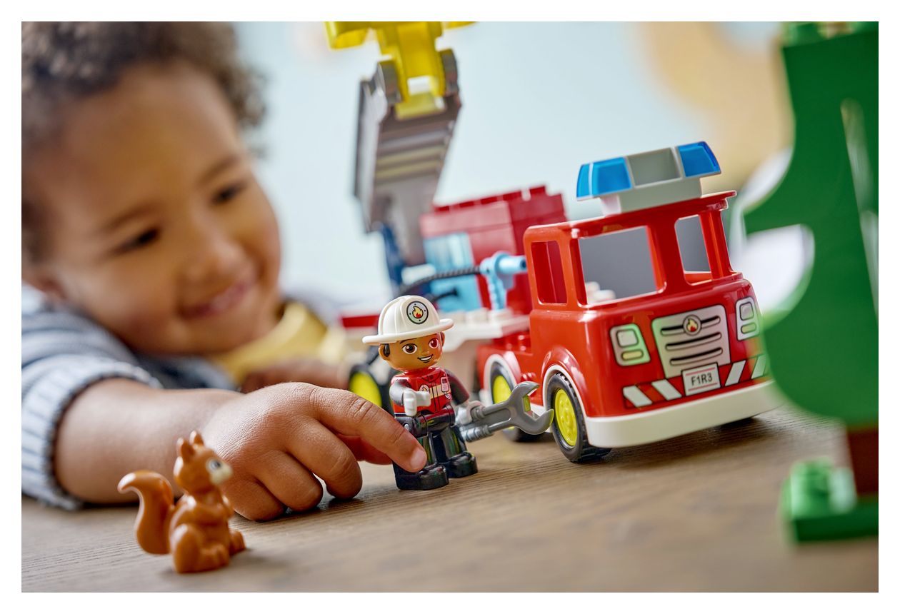 Löschauto mit Schlauch und Feuerwehrmann 